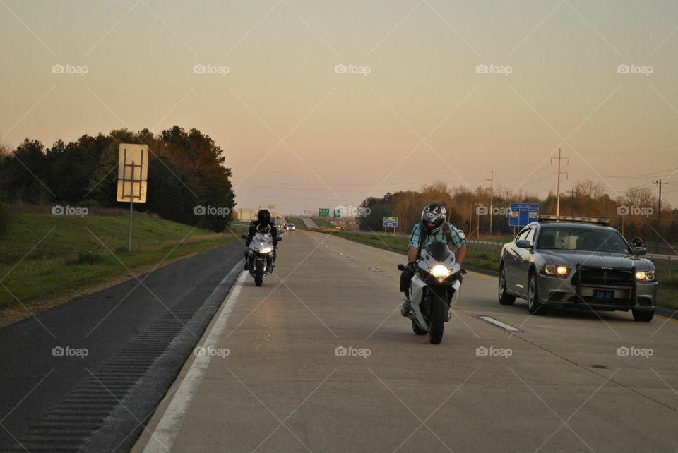 Riding motorcycles at dusk.