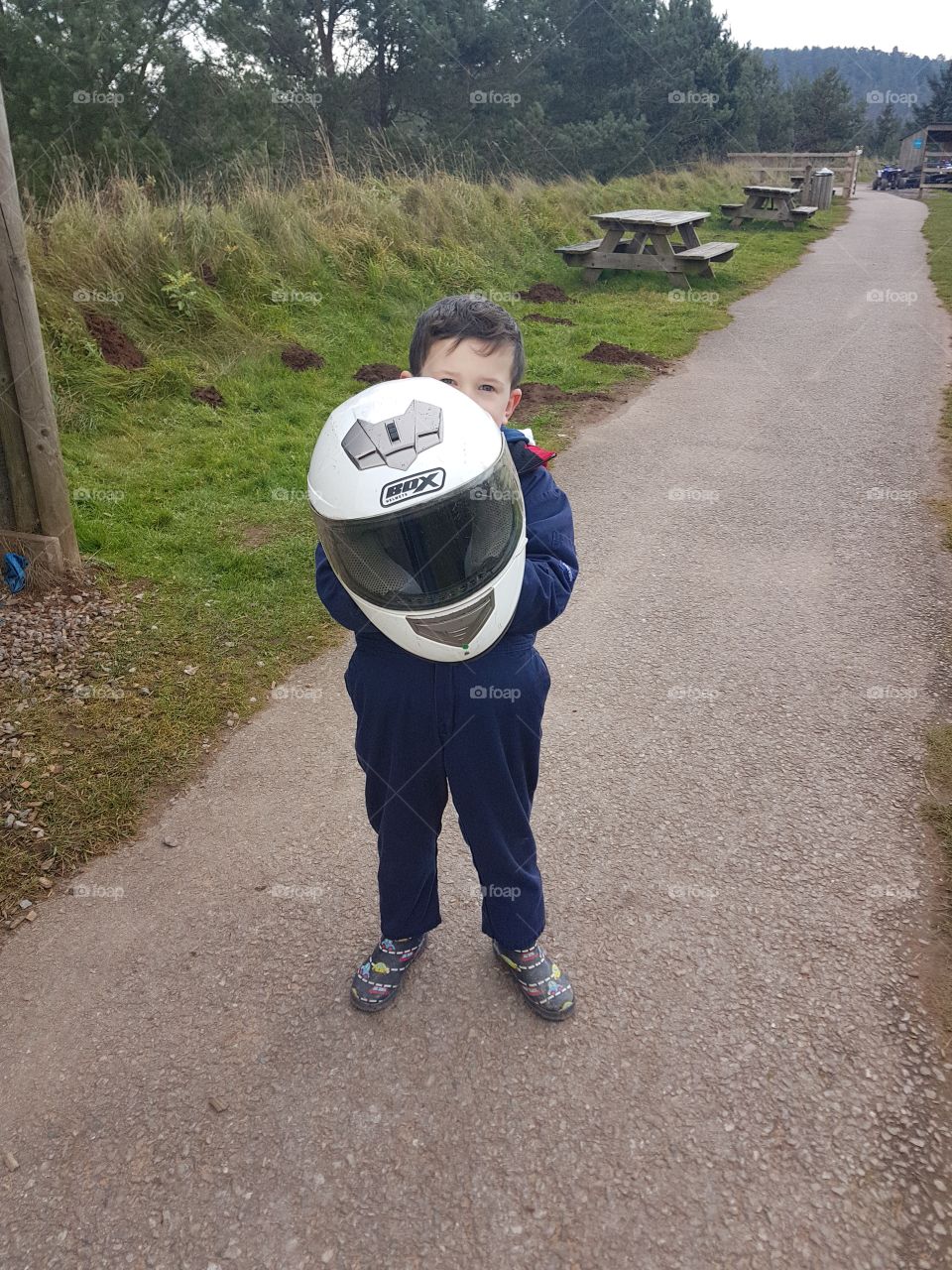 Young boy holding a quad bike helmet