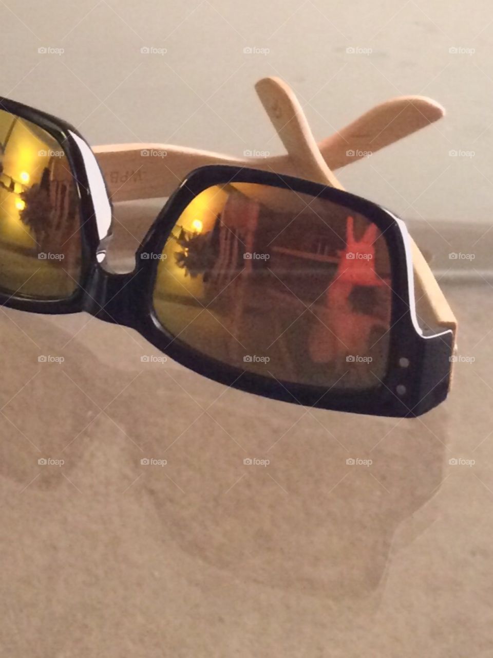 Yellow bamboo sunglasses and reflection on glass 