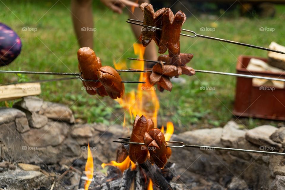 cooking the sausages and meat over the fire