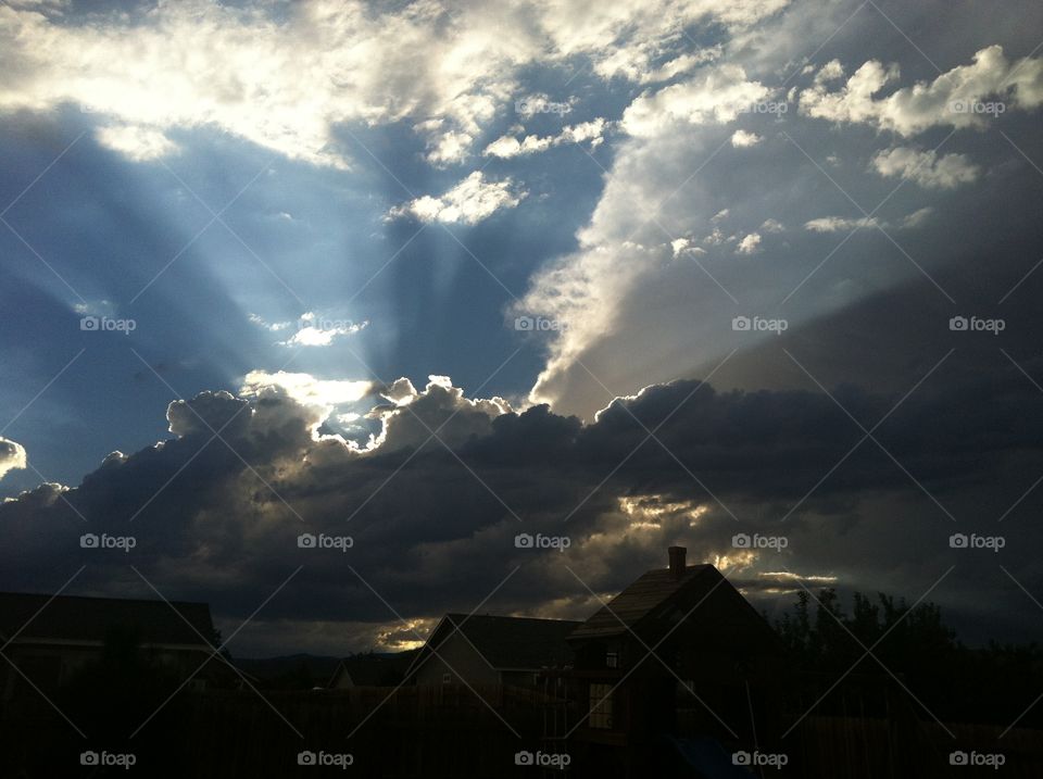 The sun peaking out of the dark clouds