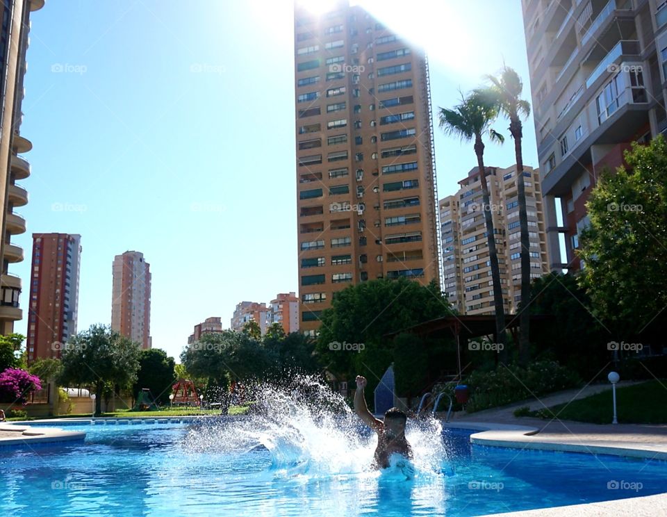 Svimmingpool#urban#buildings#water#human#splash#palms#jump