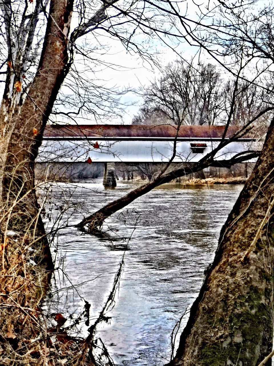 Cold winter day and an old Indiana Covered Bridge on the river 