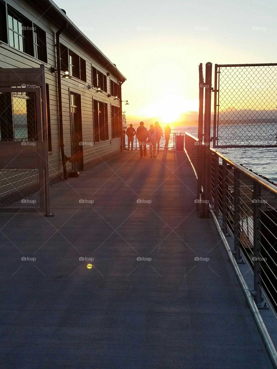 People at dock during sunset