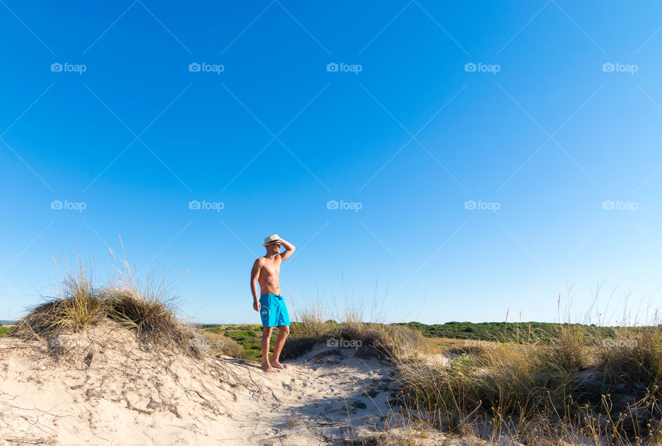 Portrait of young man standing on sand