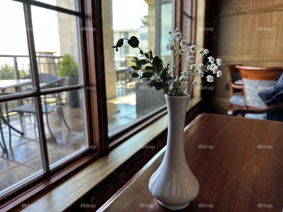 White vase with dry flowers by the window 