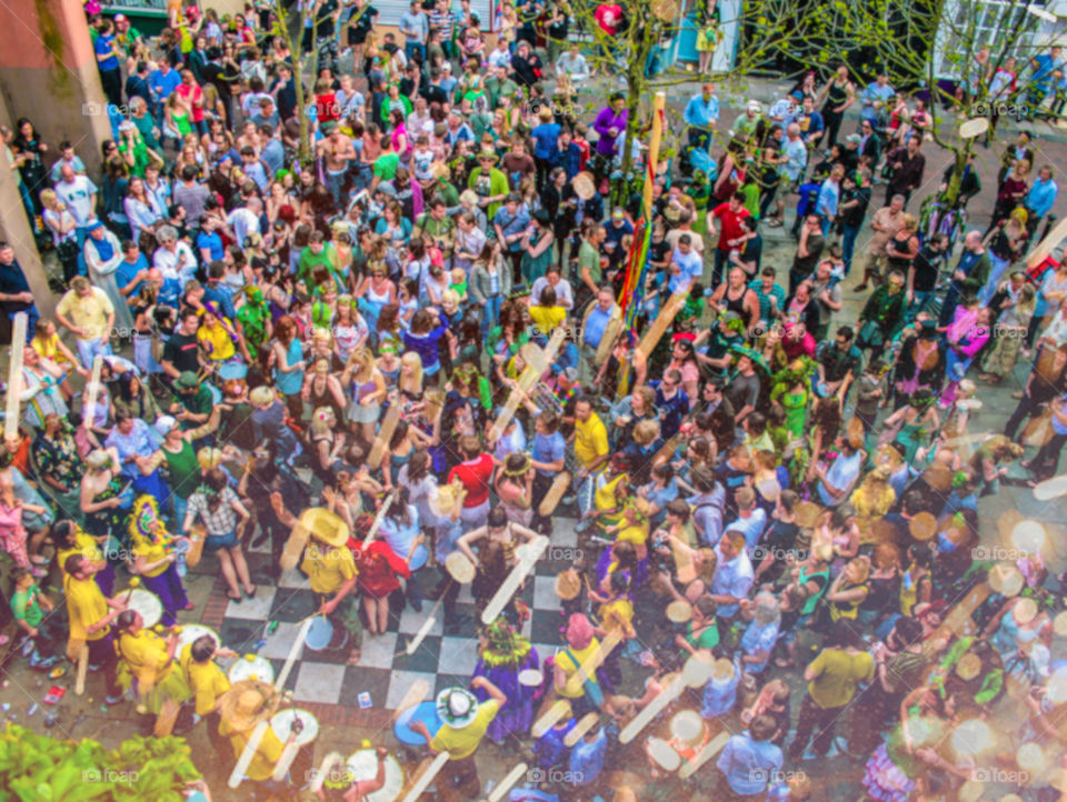 Birds eye view of a crowded public square of people celebrating a local event, a samba band is playing in one corner and the scene is full of exuberance and merriment