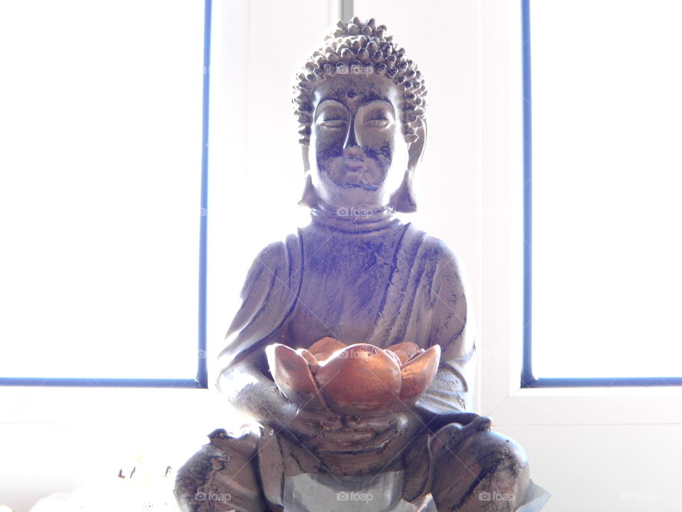 nice Buddha on the window and sunlight