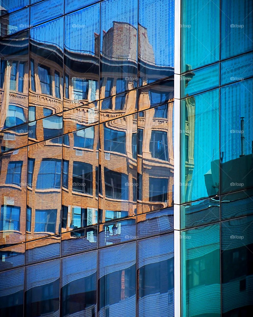 Reflections of an old building in the windows of another building.