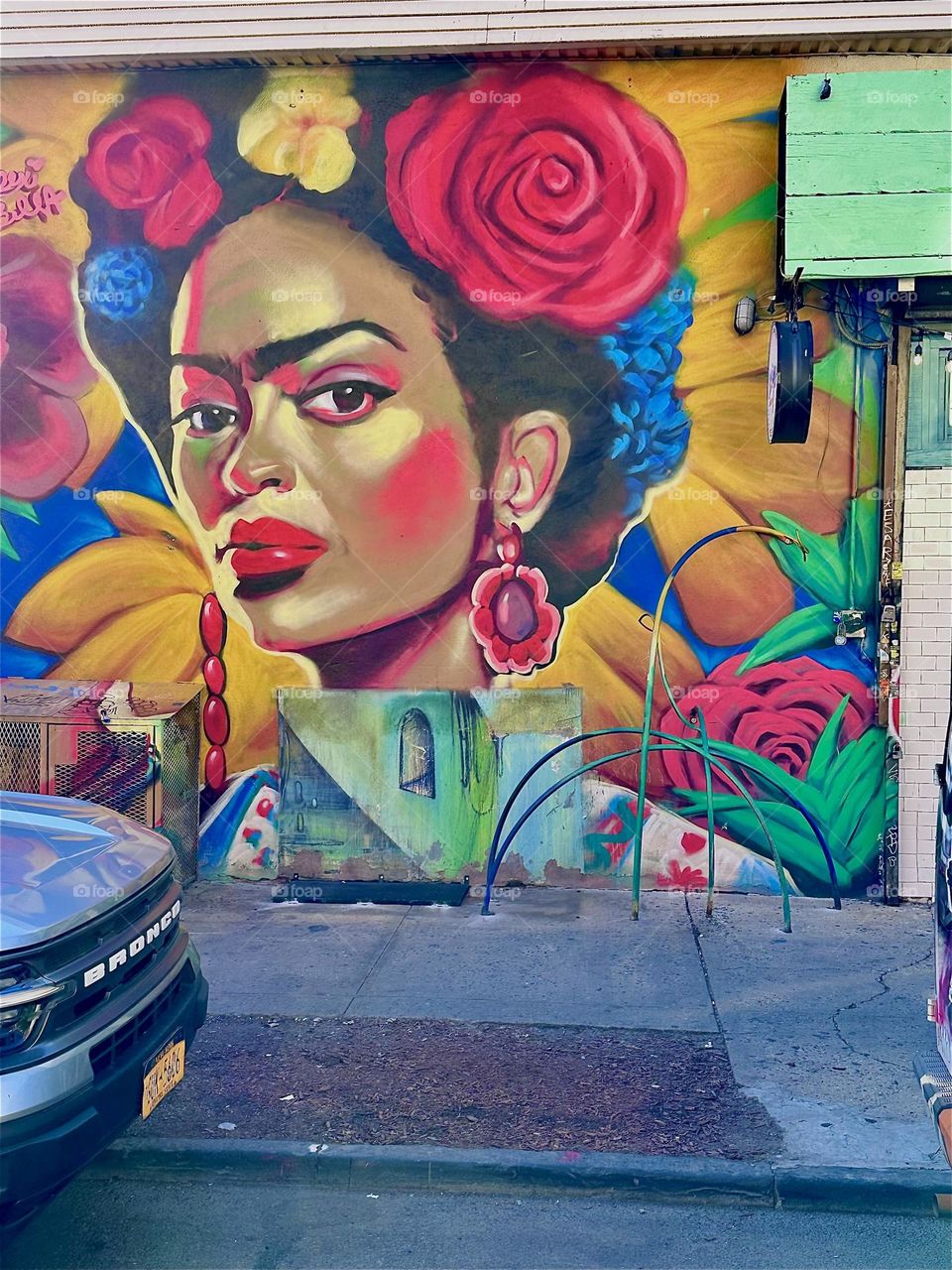 This mulatto Latina is part of a large colorful art mural that spans almost an entire city block on “Jefferson Street” and “Broadway” in “Bushwick”, Bklyn. I am here once again to visit “MG Pharmacy” like I do every month. 2024. Hypnotic Productions