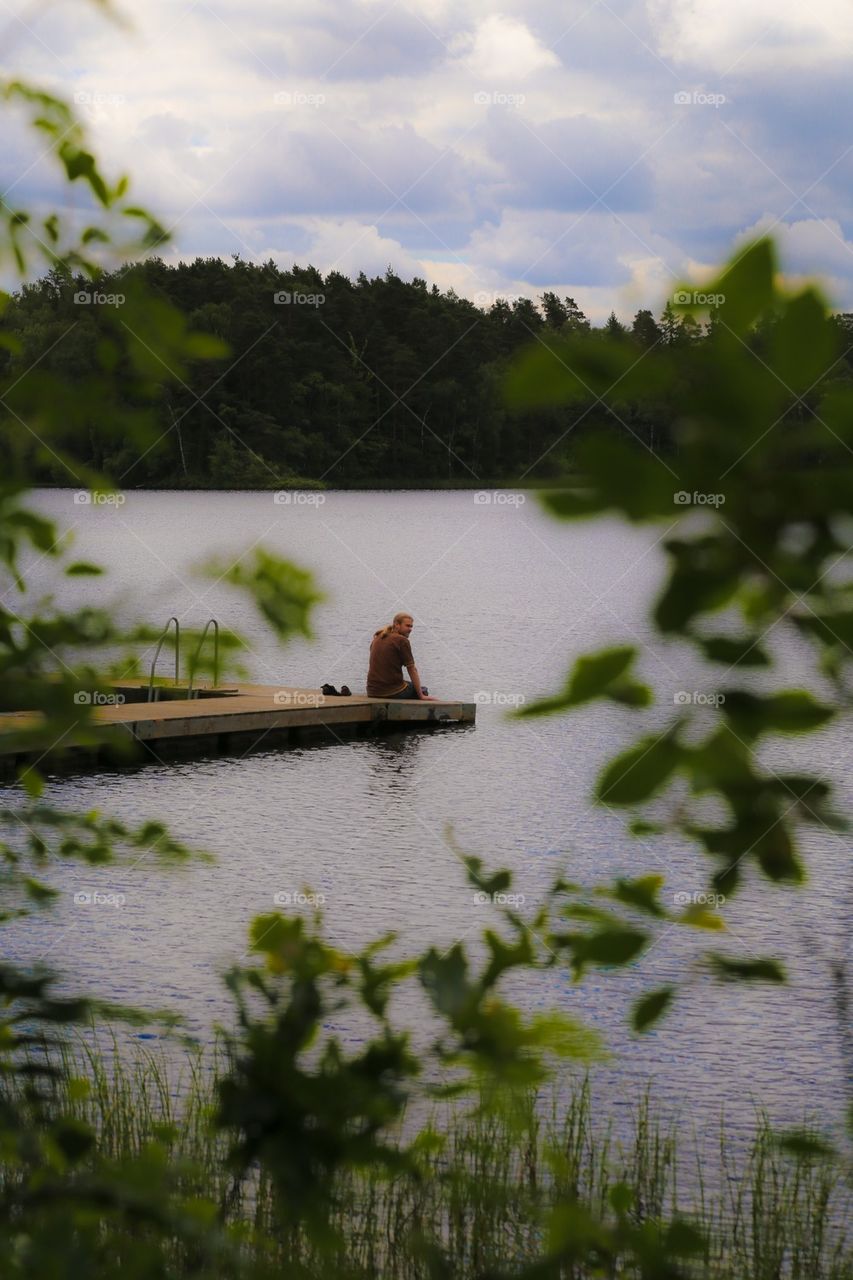 Summer by the lake. Man on the jetty