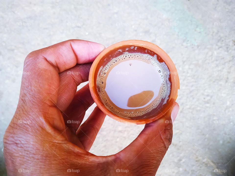 A tea served in a natural clay cup with background