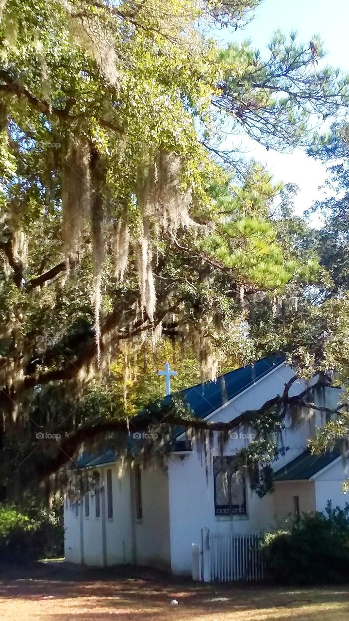 old chapel in Pawleys Island SC under the late afternoon shade of historic oak trees and Spanish Moss