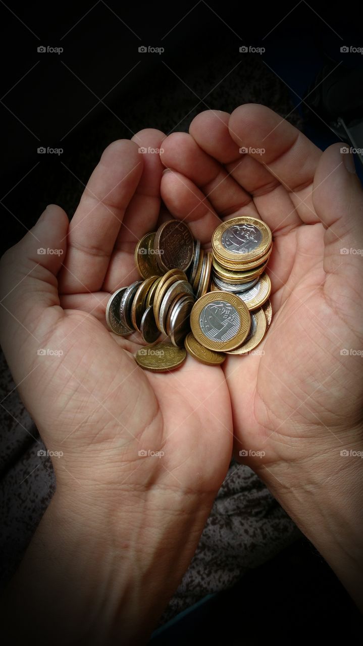 Mãos com moedas.