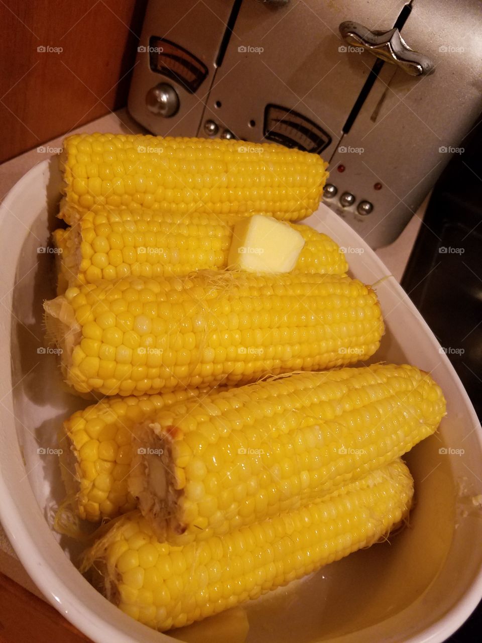 A cube of butter on corn on the cobs