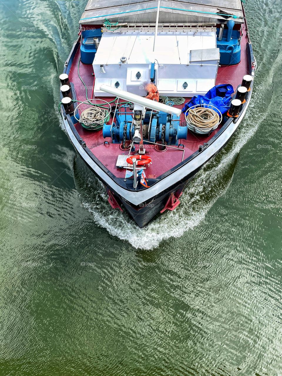 Top view of a cargo ship passing under a bridge in a canal