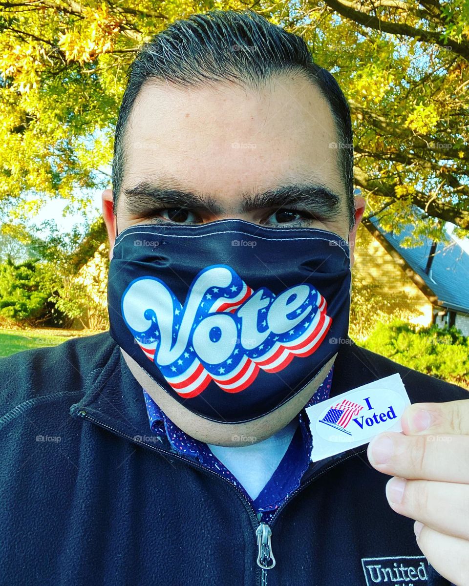 Man in “Vote” mask with “I Voted” sticker