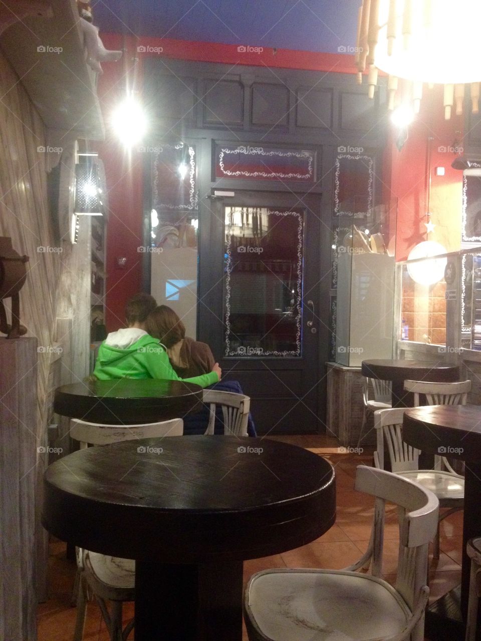 A couple sitting and embracing in a bakery 