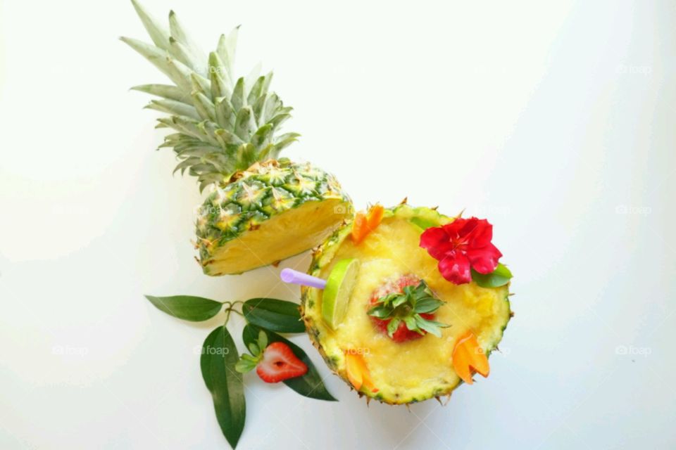 Pineapple fresh fruit smoothie - topped witj strawberry,  carrots and lime