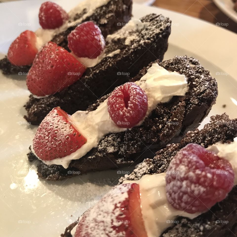 Chocolate brownies with cream, strawberries and raspberries