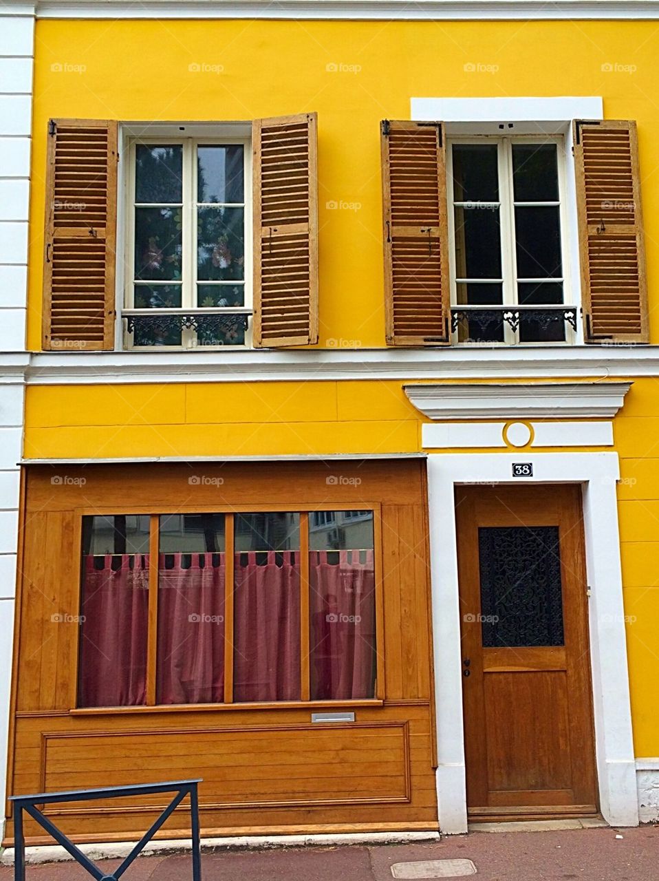 Wooden shutter window frames on yellow wall