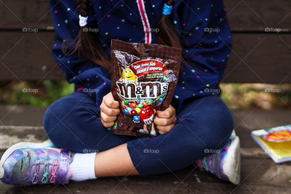 Little girl with pack of M&Ms