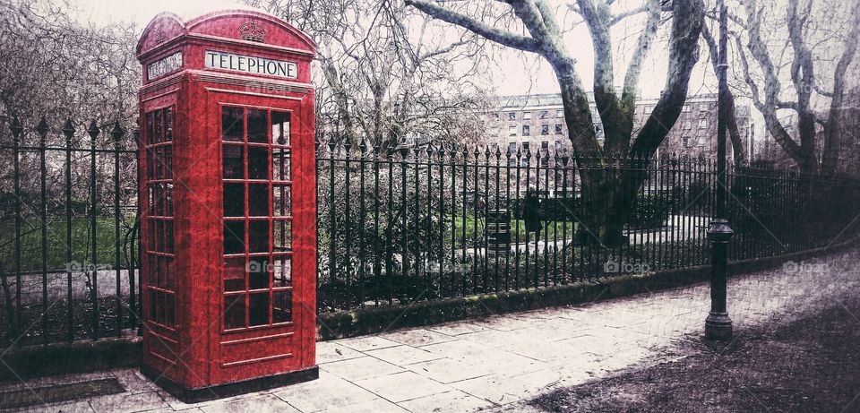 a red London telephone box on a foggy day.