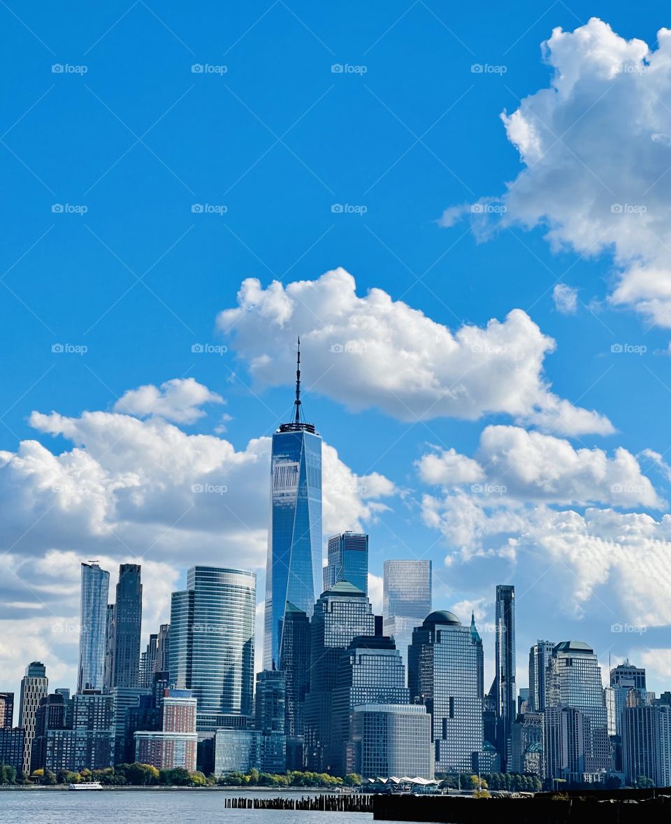 City escape - The Freedom Tower soars among the clouds serenely and majestically on the shoreline of downtown Manhattan. 