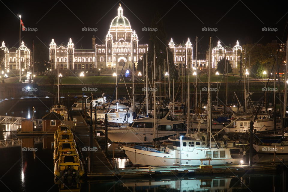 Victoris vancoucer Island legislature building lit up and marina by night in the foreground 