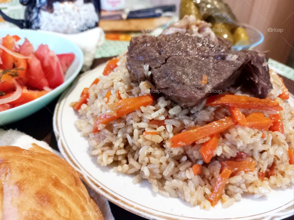 today for lunch we had pilaf with meat, salad with tomatoes, pickled cucumbers and flatbread, an Uzbek national dish.