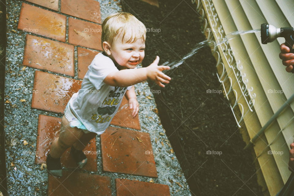 happy boy playing in water