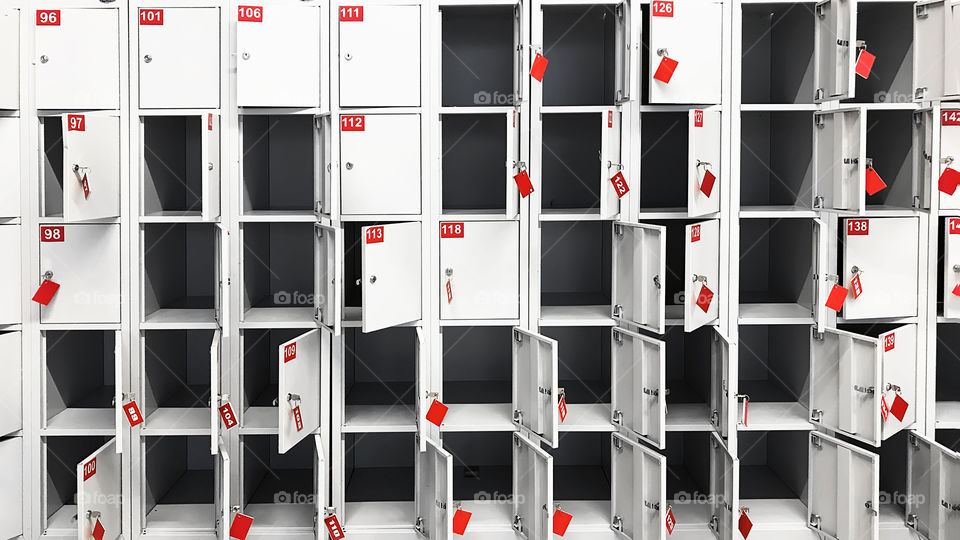 Many rows of white opened and closed boxes with red numbers and keys 
