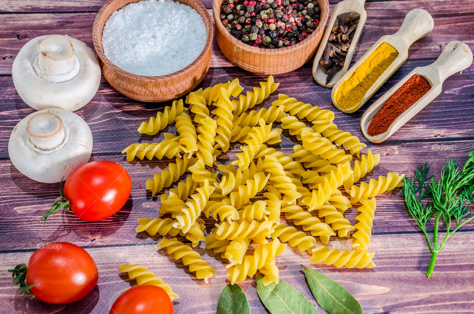 Raw pasta with ingredients and wooden accessories