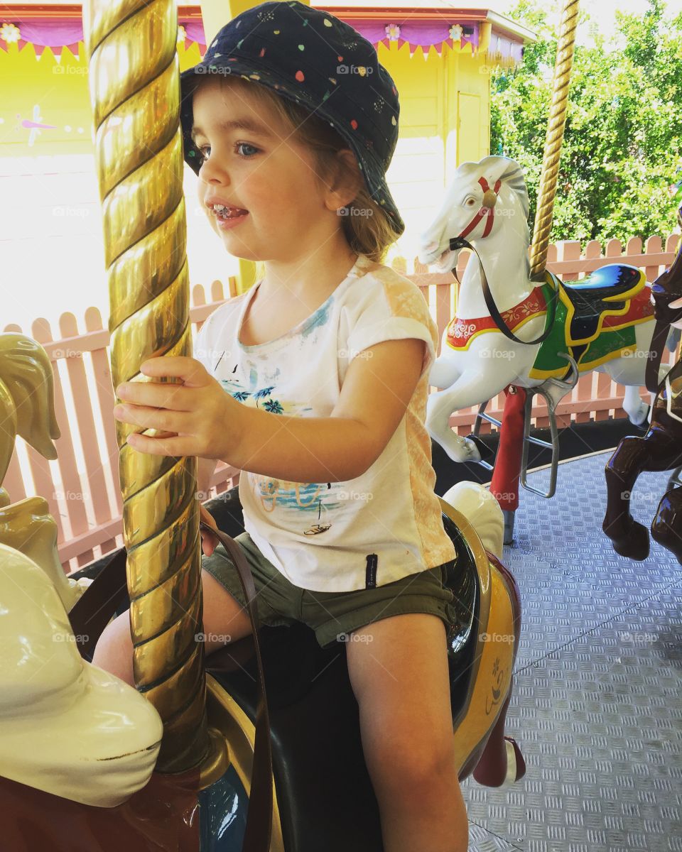 Cute girl riding on carousel