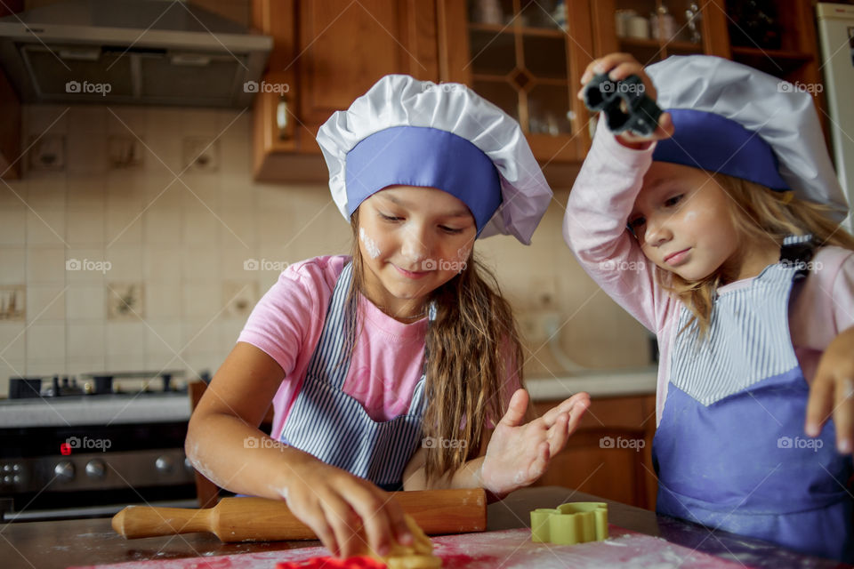 Little sisters cooking the biscuits 