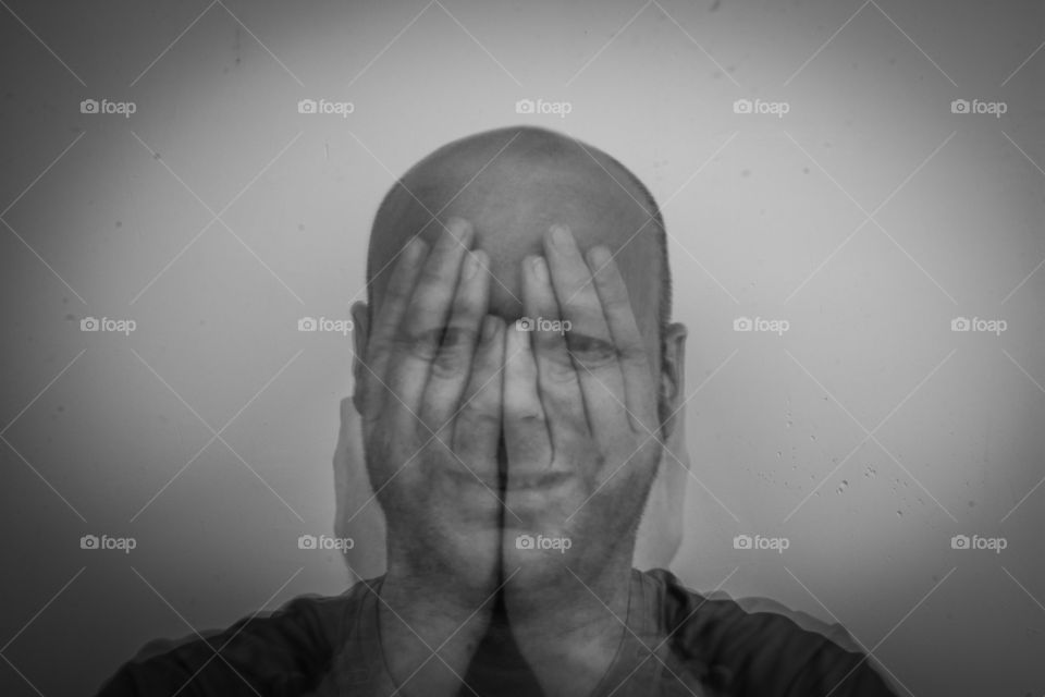 Multi exposure of man covering his face