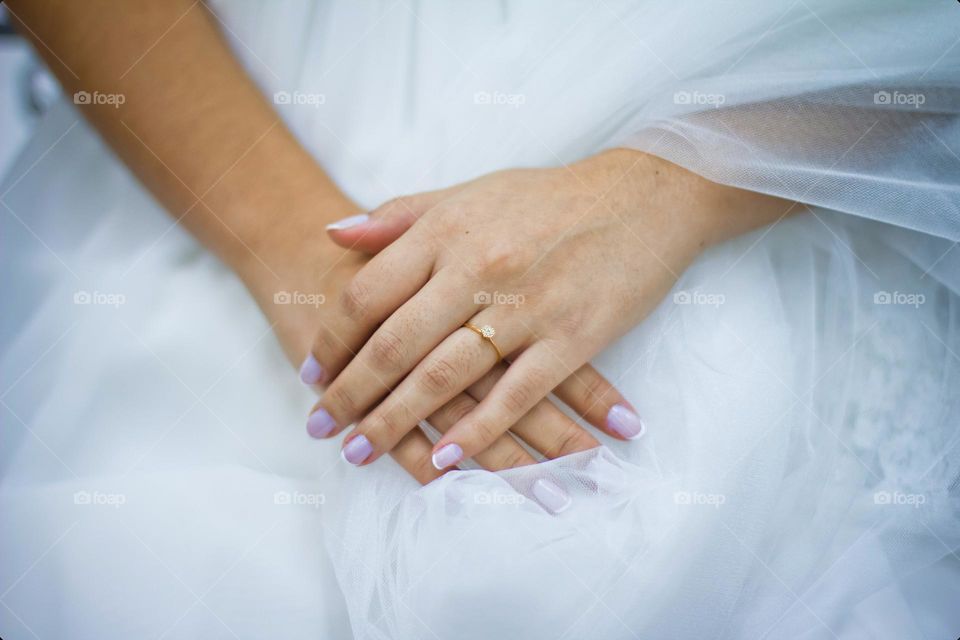 Hands of the bride and a gold ring