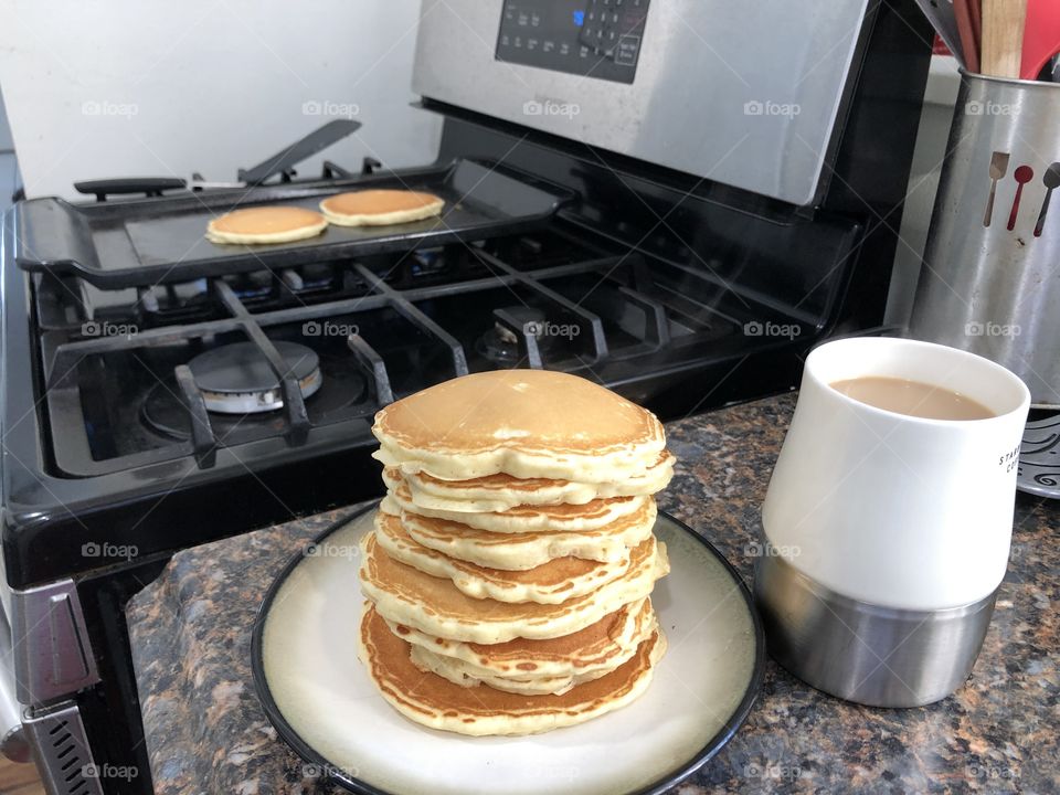 Stack of pancakes with coffee on kitchen counter