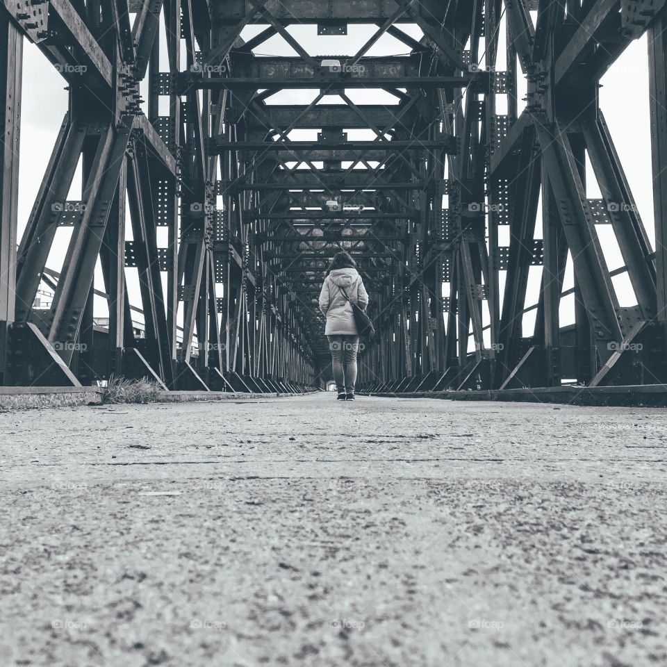 Person waking under the bridge