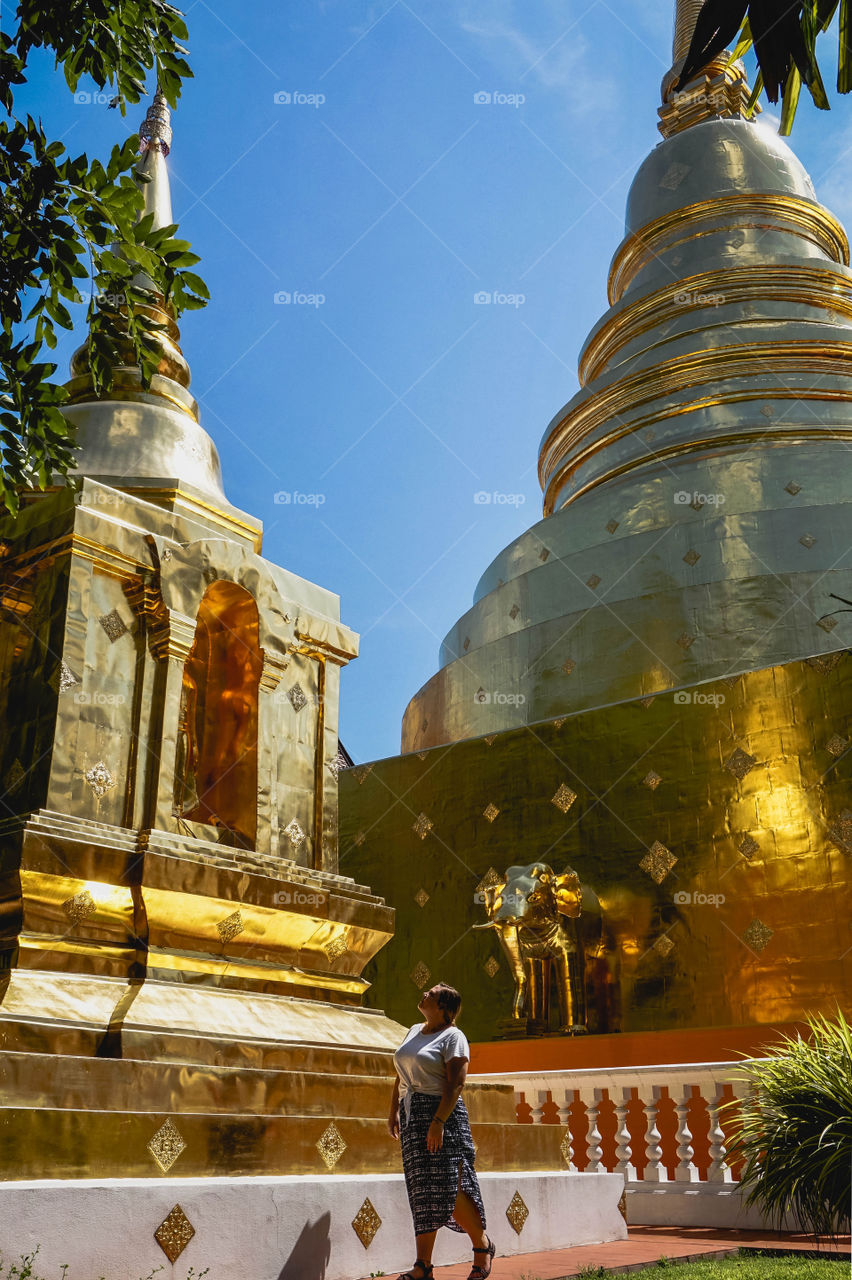 Woman admiring golden stupas, Chiang Mai, Thailand 