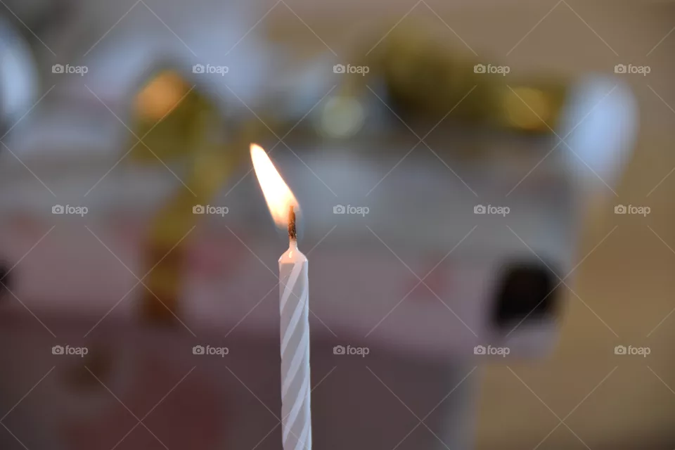 A burning Birthday candle with focus on foreground 