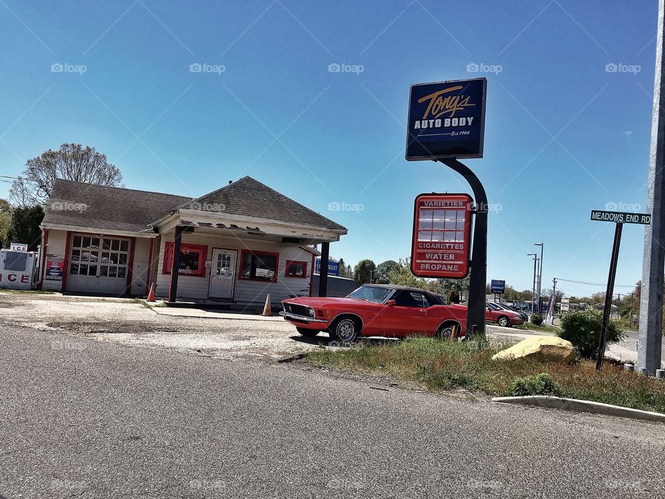 Antique red car at an unused gas station 