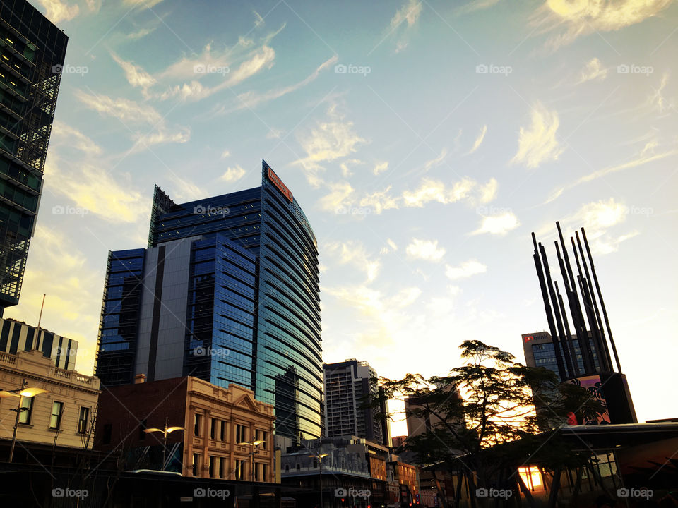 Sunset time at magic hour on Wellington Street, Perth, Western Australia. Commercial buildings and Digital Tower at Yagan Square can be seen along the street.