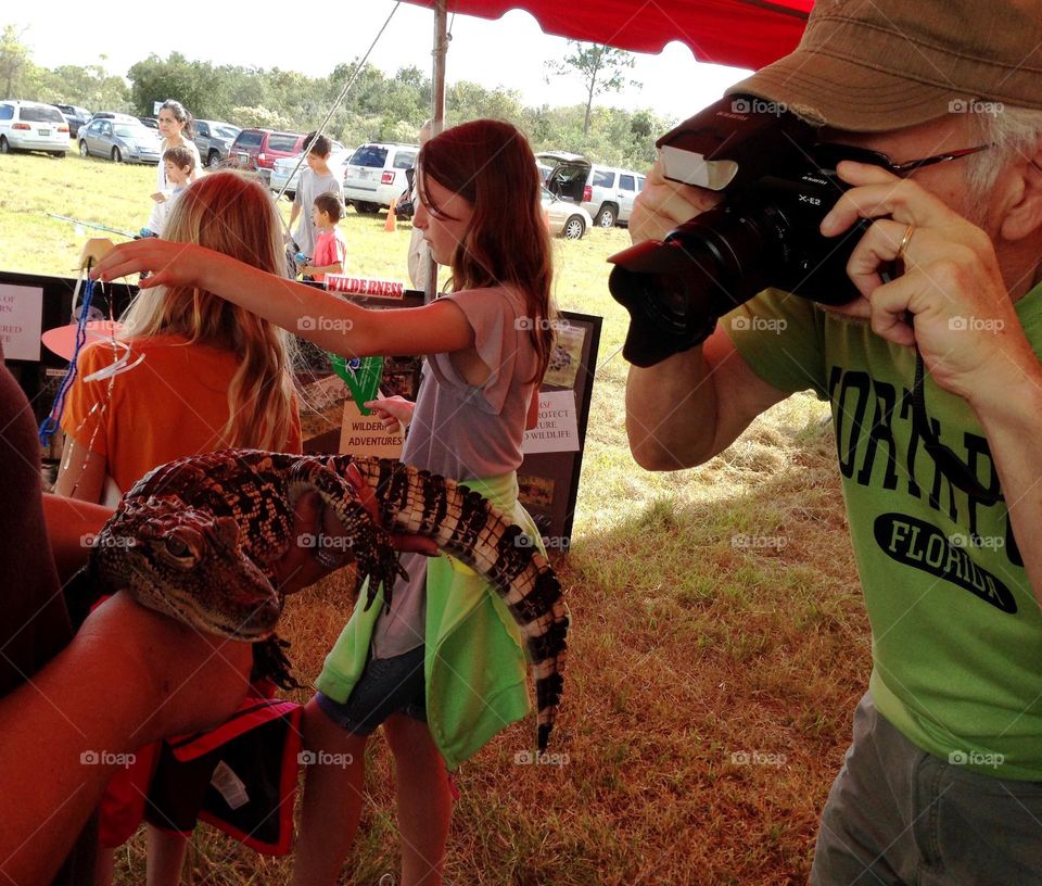 Videographer creating content with a baby alligator.