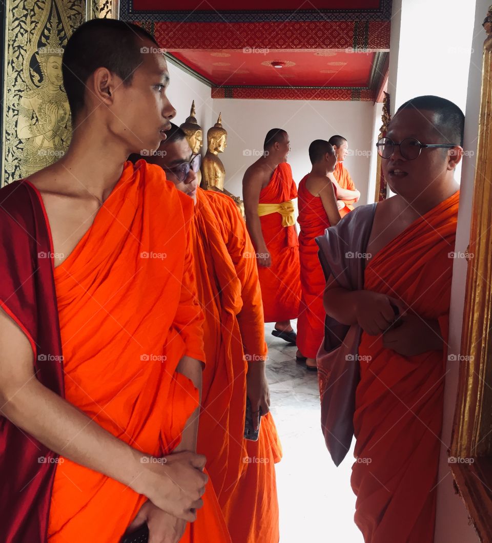 Young monks gather in a hallway in Wat Pho, the temple of the reclining Buddha in Bangkok Thailand