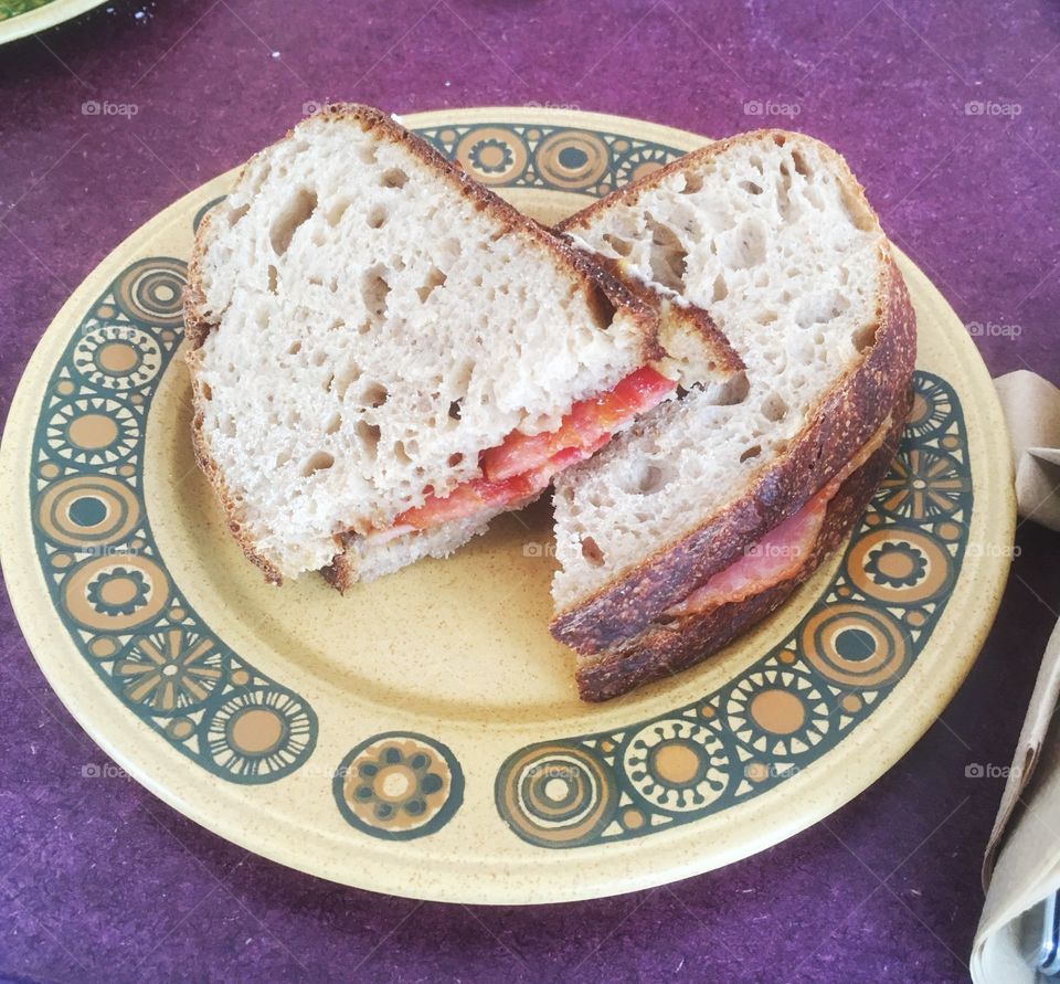 Bacon sandwich on sourdough bread on a vintage plate