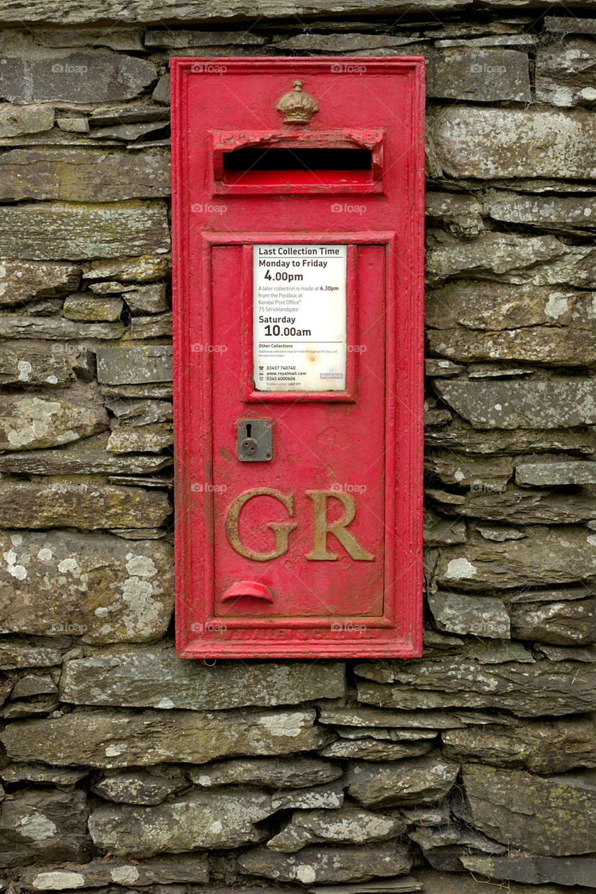 Red GR postbox set in an old stone wall