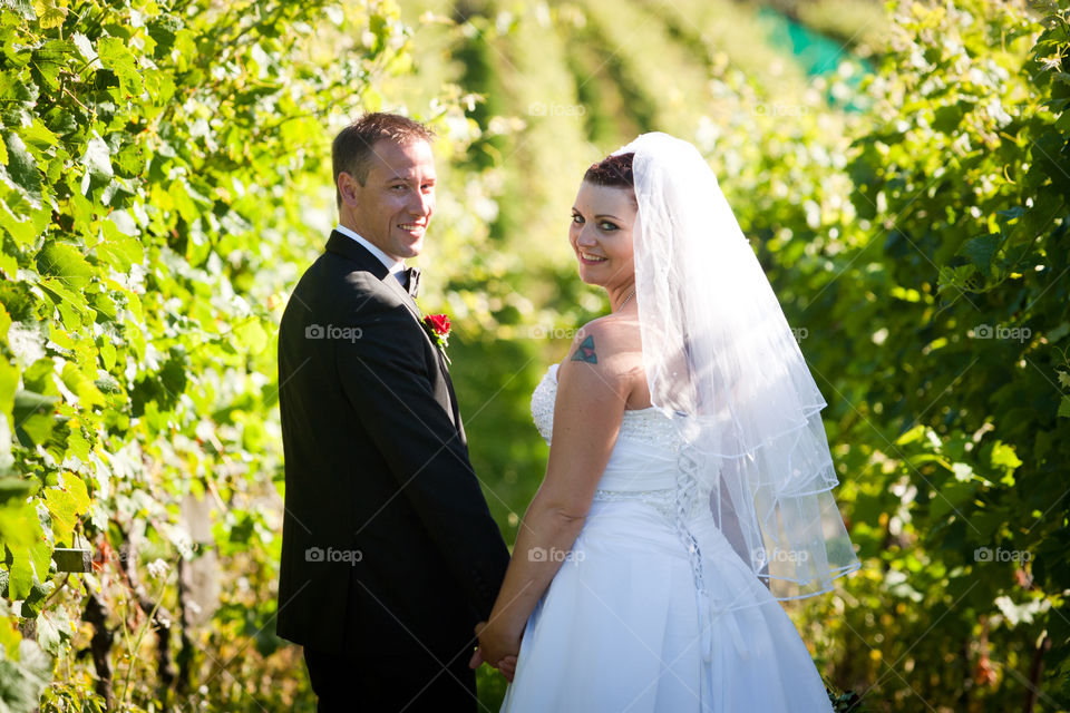 Rear view of bride and groom looking at camera