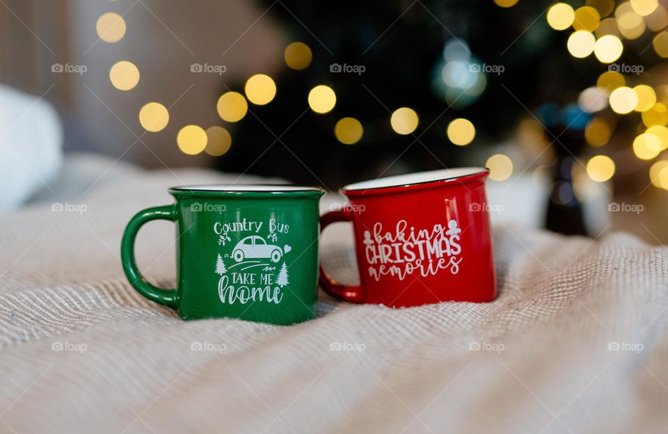 Two Christmas mugs with festive prints. Holiday mood. Hot beverages