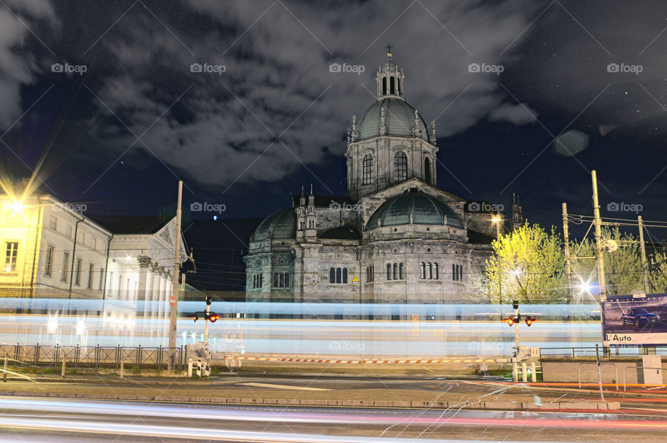 Ghost train: Night with a train passing behind the Como cathedral